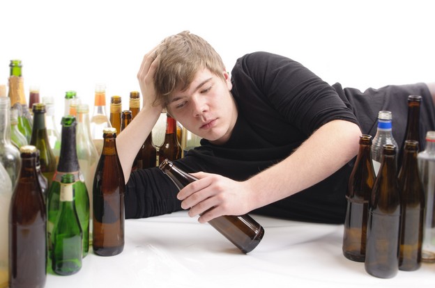 Подросток лежит в окружении бутылок 