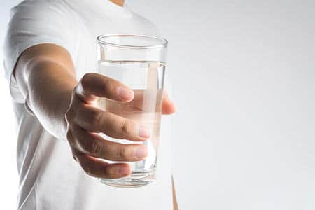 стакан воды в руке