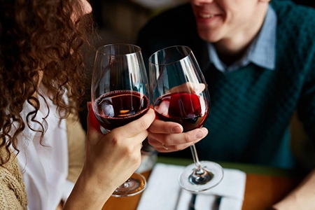 мужчина и женщина пьют красное вино